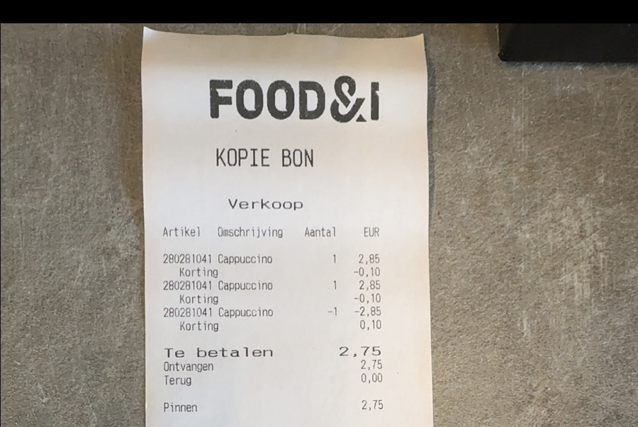 Een kassabon op tafel, gefotografeerd met de camera van een telefoon.